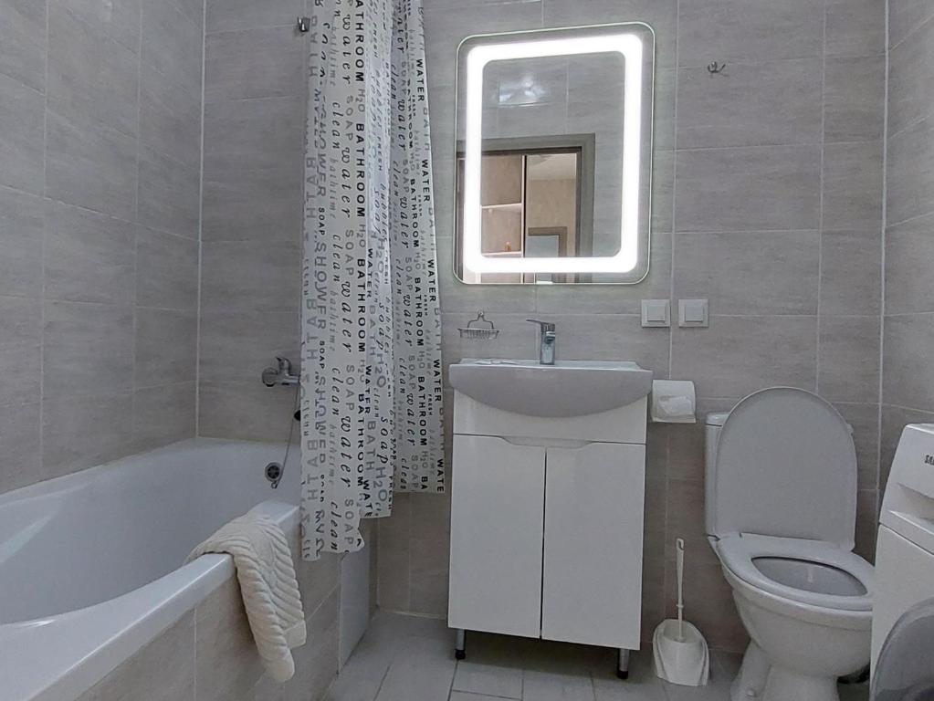 a bathroom with a sink and a toilet and a mirror at DreamTown Однокімнатна біля вокзалу in Luts'k
