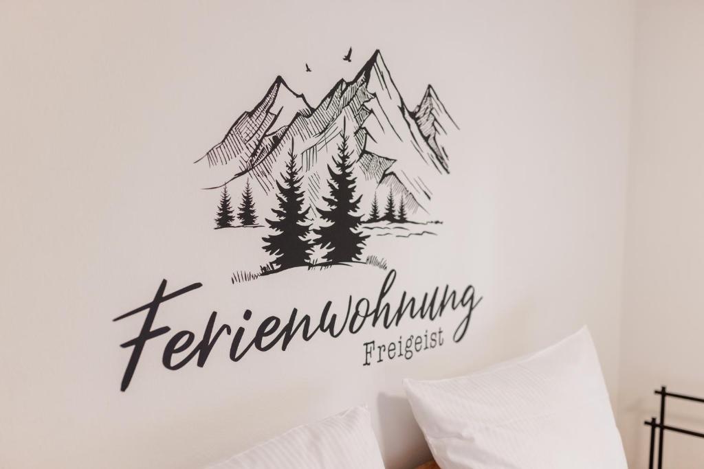 1 dormitorio con una pegatina de montaña en la pared en Freigeist, en Nesselwang