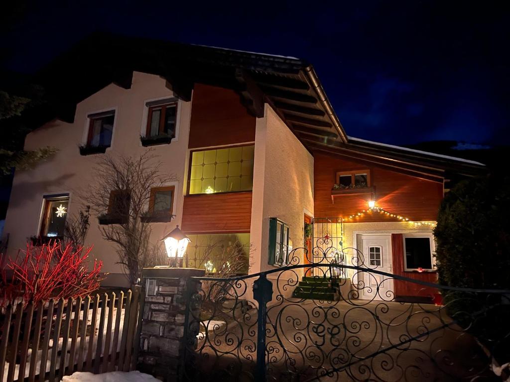 a house with a fence in front of it at night at Appartement Mountainrelax Gastein in Dorfgastein