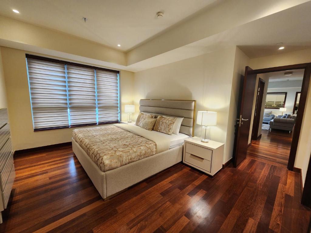 a bedroom with a bed and a large window at Opulent Comfort in Colombo