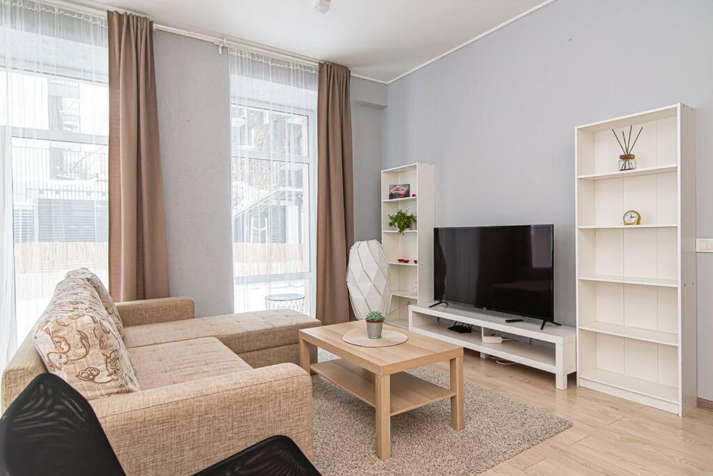 un soggiorno con un divano e una televisione di Spacious Apartment with Great Location/URBAN RENT a Vilnius