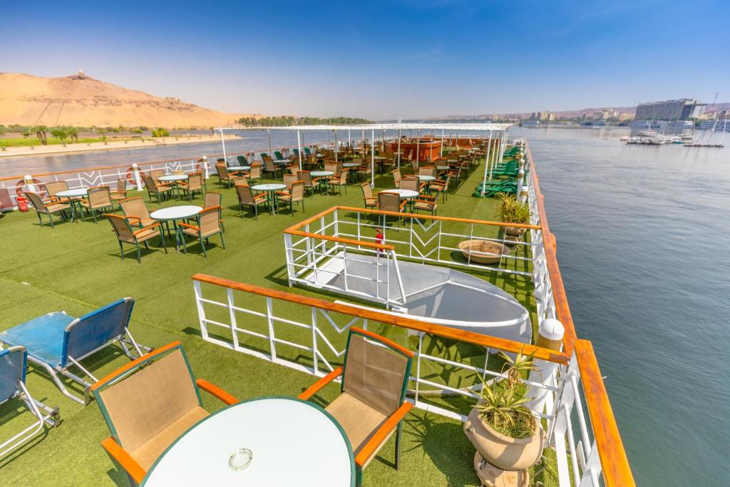 M/S Nephtis Nile Cruise في الأقصر: صف من الطاولات والكراسي على قارب في الماء