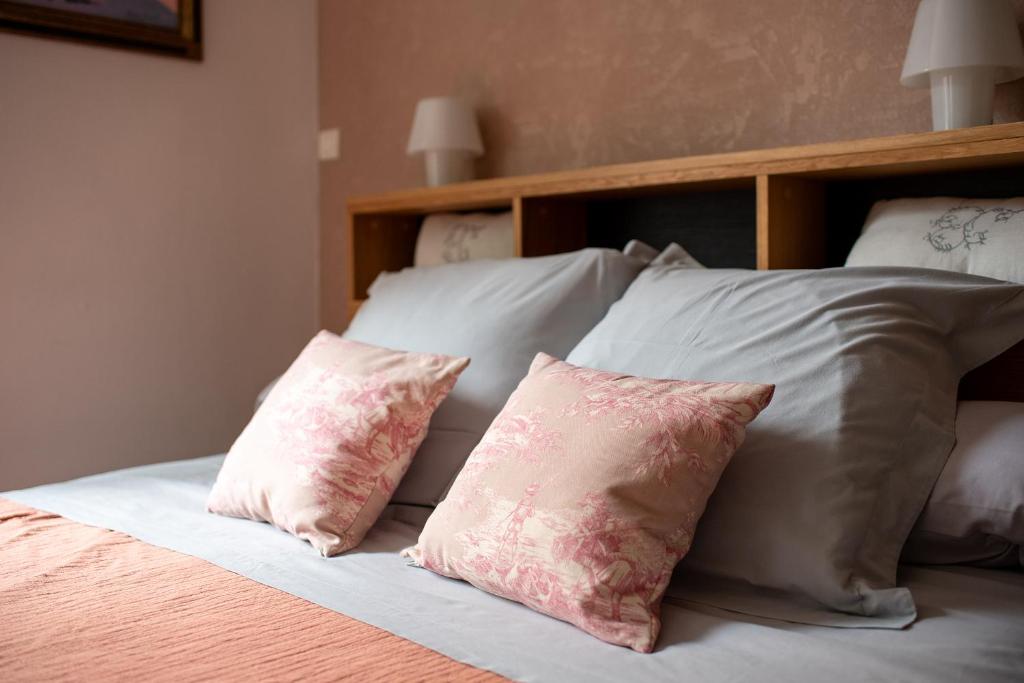 a bed with two pink pillows on top of it at Au Nid de la Madeleine in Gaillac