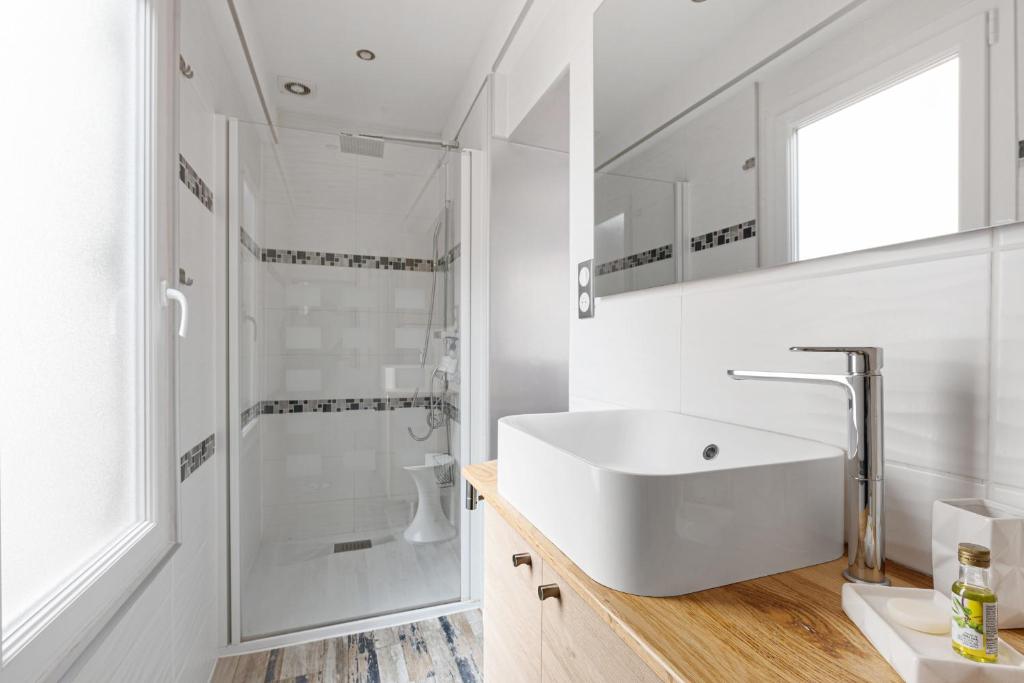a white bathroom with a sink and a shower at Au Nid de la Madeleine in Gaillac