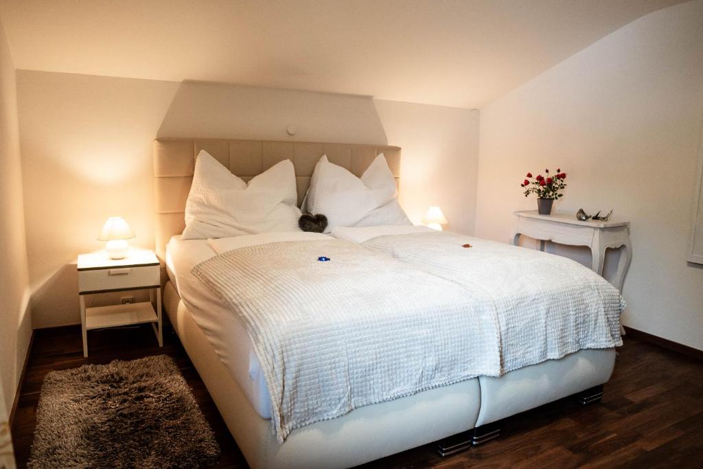 a bedroom with a large white bed with a cat sitting on it at Appartement Mountainrelax Gastein in Dorfgastein