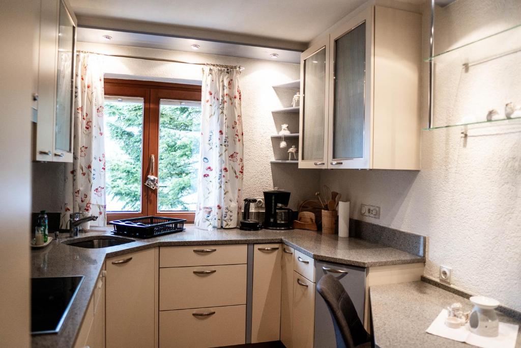 a small kitchen with white cabinets and a window at Appartement Mountainrelax Gastein in Dorfgastein