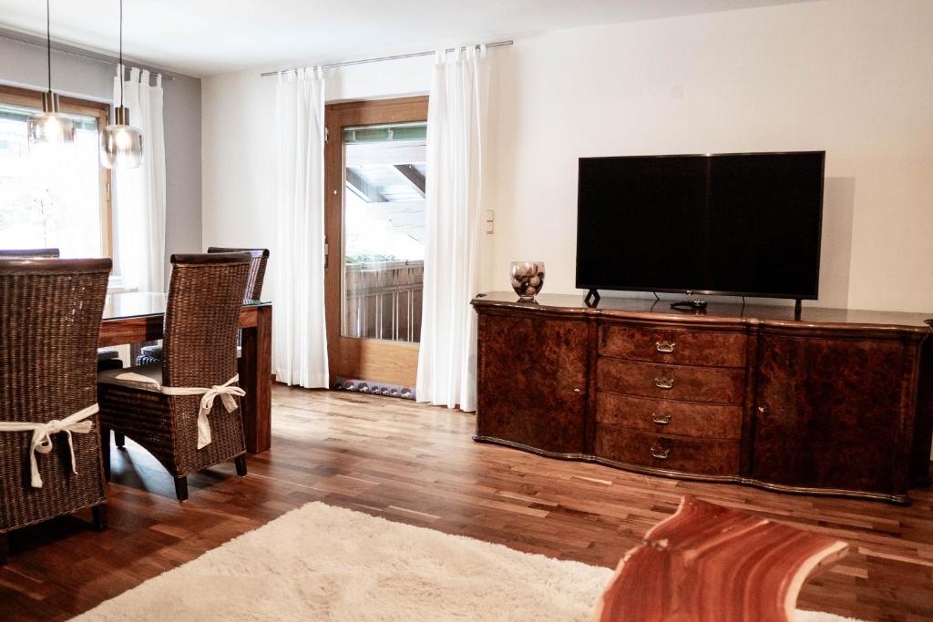 a living room with a flat screen tv on a dresser at Appartement Mountainrelax Gastein in Dorfgastein