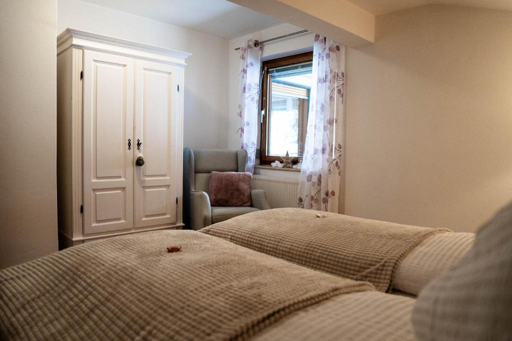 a bedroom with two beds and a chair and a window at Appartement Mountainrelax Gastein in Dorfgastein