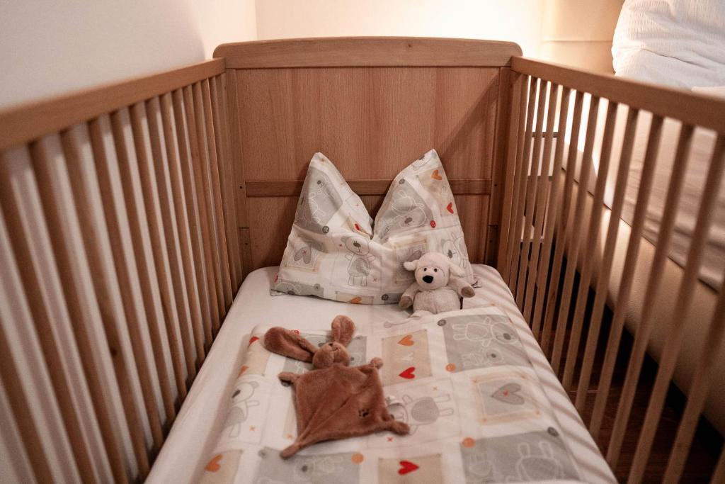 a crib with two stuffed animals sitting on it at Appartement Mountainrelax Gastein in Dorfgastein