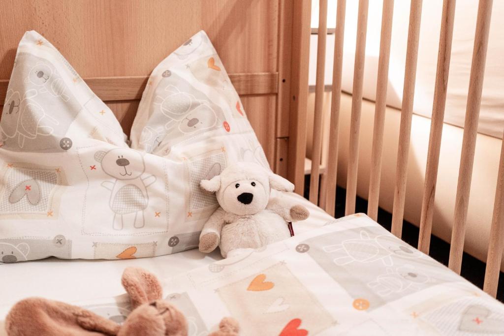 a white teddy bear sitting in a crib at Appartement Mountainrelax Gastein in Dorfgastein