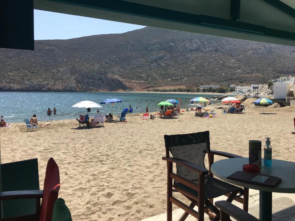 um grupo de pessoas em uma praia com guarda-sóis em Cozy Studio in Beautiful Apollonas Beach Naxos em Apollon