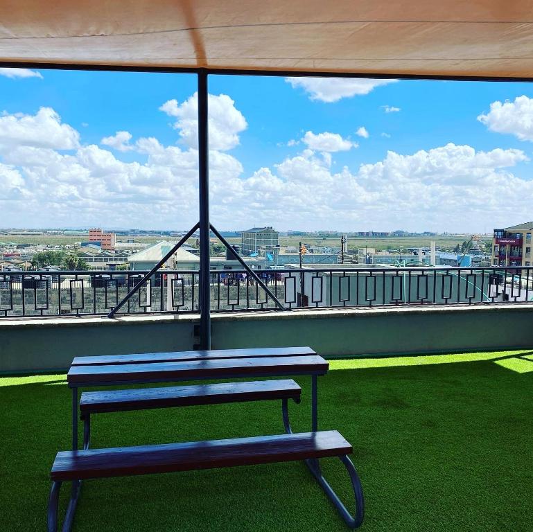 un banco azul sentado en la parte superior de un techo en Lovely & Cozy Compact Studio Near Airport with Rooftop View, en Nairobi