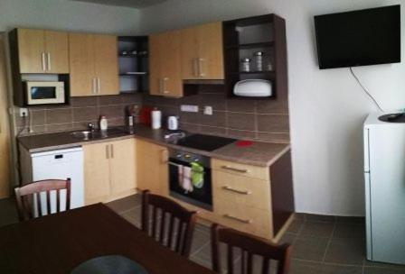 a kitchen with a table and a kitchen with a refrigerator at Apartmán u Zdeňků in Modrava