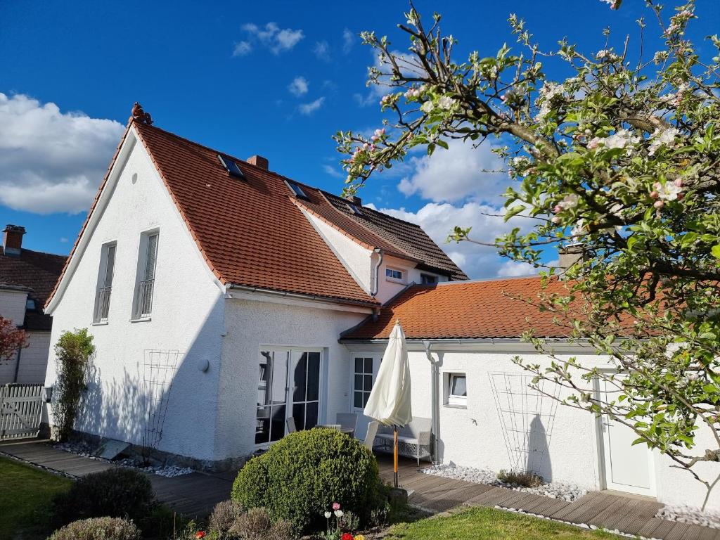 ein weißes Haus mit orangefarbenem Dach in der Unterkunft Ferienhaus Rosengarten in Selb