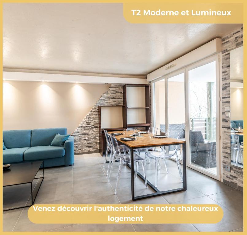 a living room with a blue couch and a table at Appartement T2 Moderne St Julien in Saint-Julien-en-Genevois
