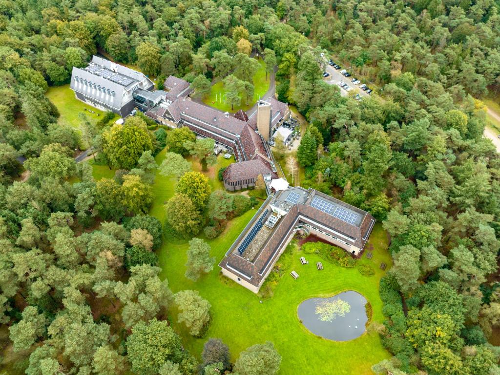 an aerial view of a building in the middle of a forest at Hotel Woudschoten in Zeist