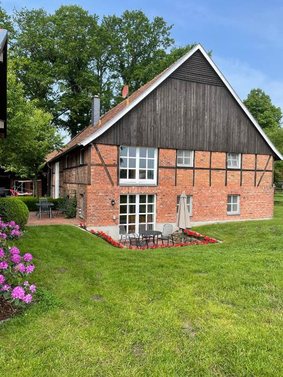 a brick building with a table and chairs in a yard at Landhaus am Esch in Warendorf