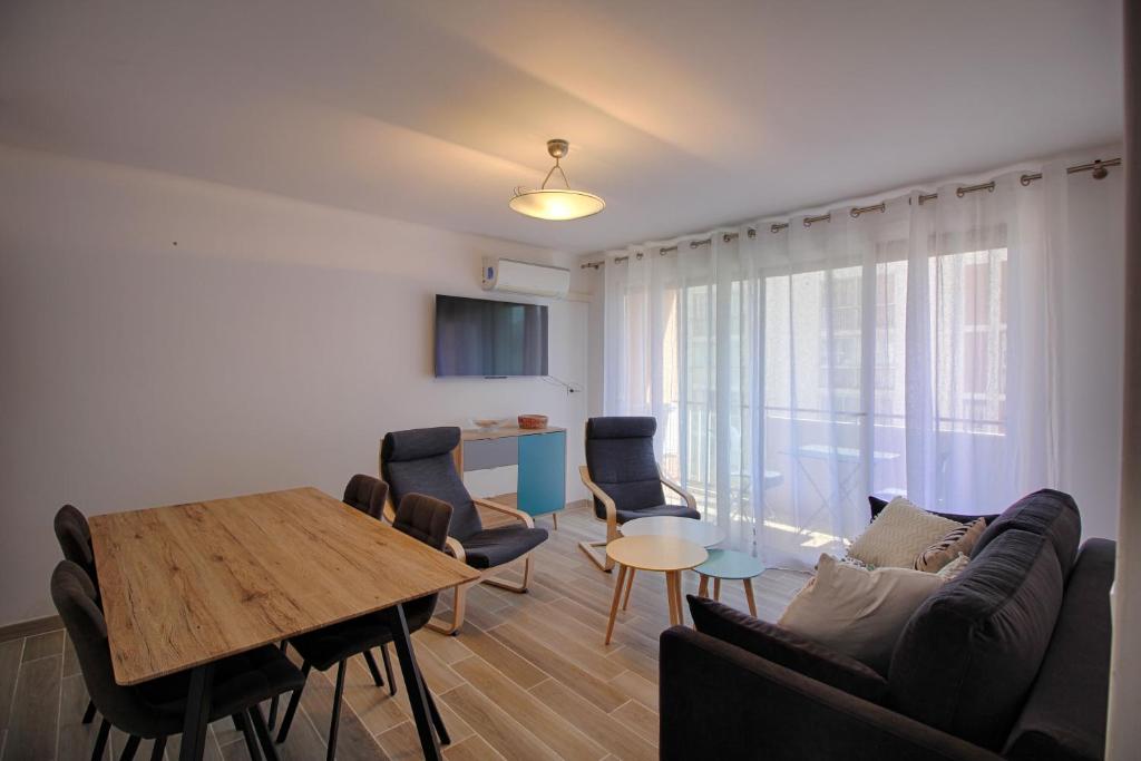 un salon avec un canapé, une table et des chaises dans l'établissement Appartement Eugénie centre-ville Ajaccio, à Ajaccio