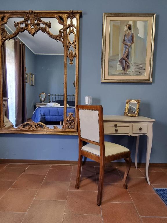 a bedroom with a mirror and a chair and a desk at VintageCo. Apartments in Motta SantʼAnastasia