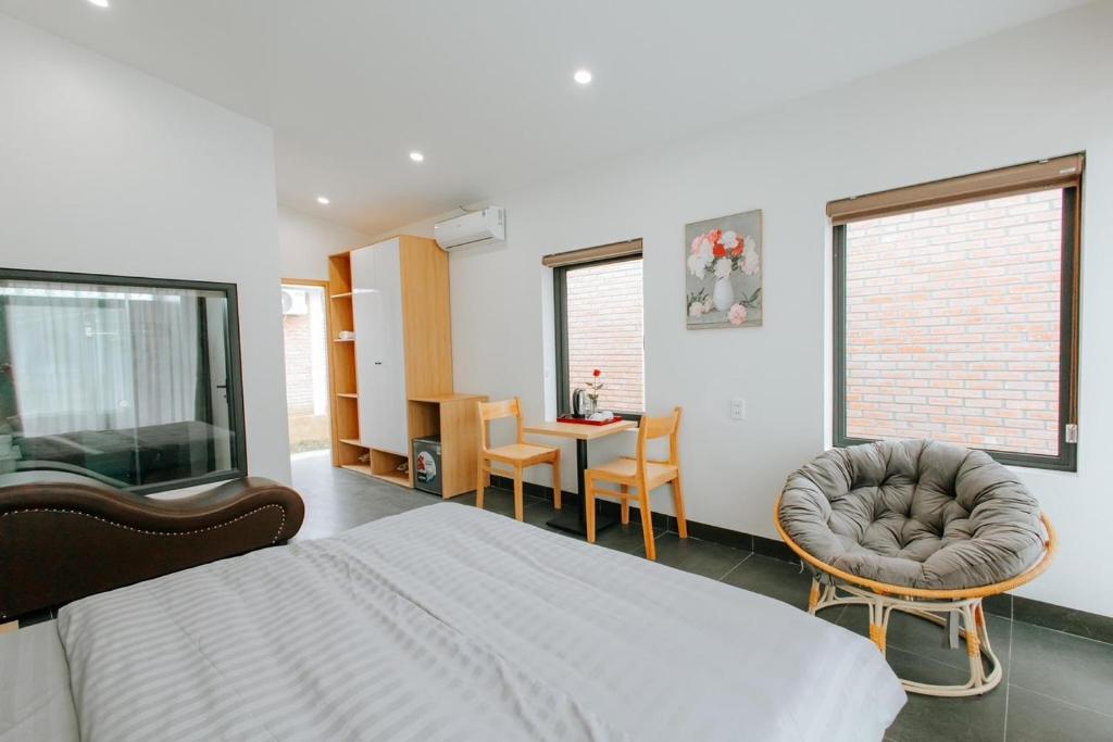 1 dormitorio con cama, sillas y mesa en Mộc Châu Mountain Retreat, en Làng Môn