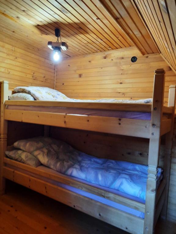 a bedroom with two bunk beds in a wooden room at Vikendica Rajvosa Vlašić in Šišava