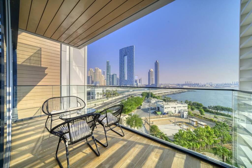 a balcony with a table and two chairs and a view of the city at Livbnb - Elegant 3BR+Maid, Sea View in Bluewaters in Dubai