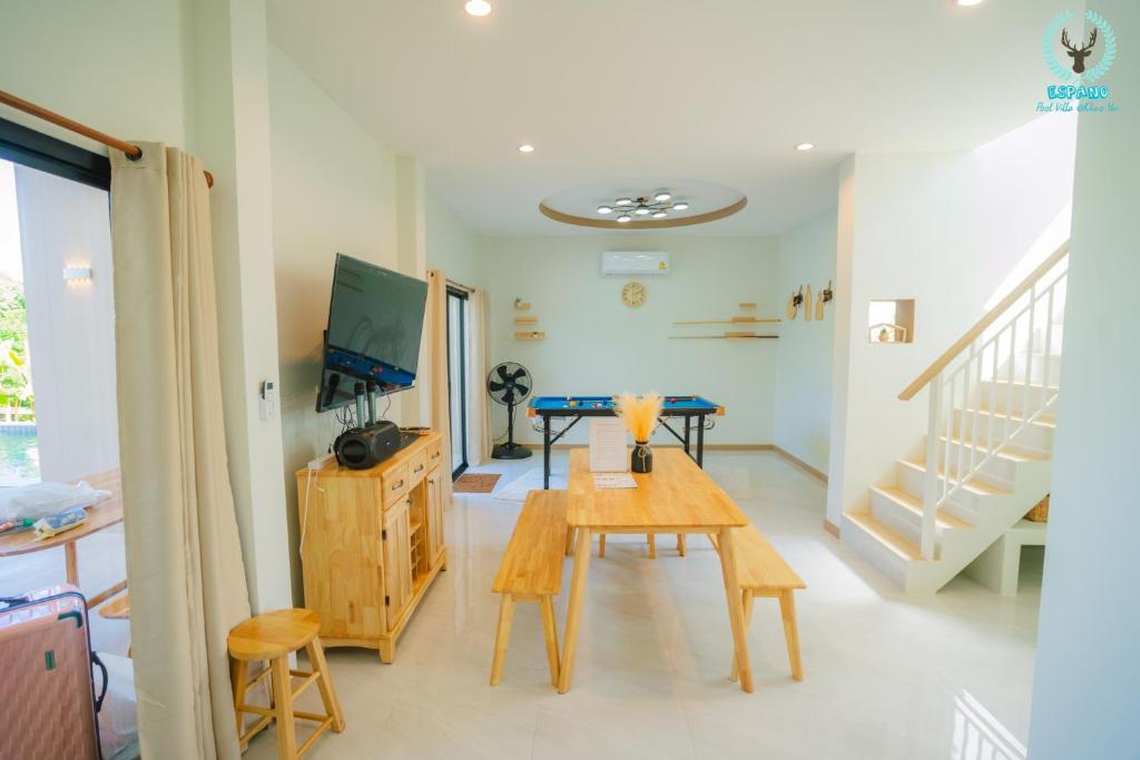 ein Wohnzimmer mit einem Tisch und einem TV in der Unterkunft Espano 1 in Ban Tha Chang