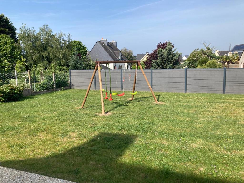 a park with a swing set in the grass at LE COQ - Maison 10 personnes - Locmariaquer in Locmariaquer