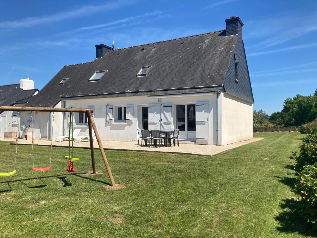 a house with a yard with a swing at LE COQ - Maison 10 personnes - Locmariaquer in Locmariaquer