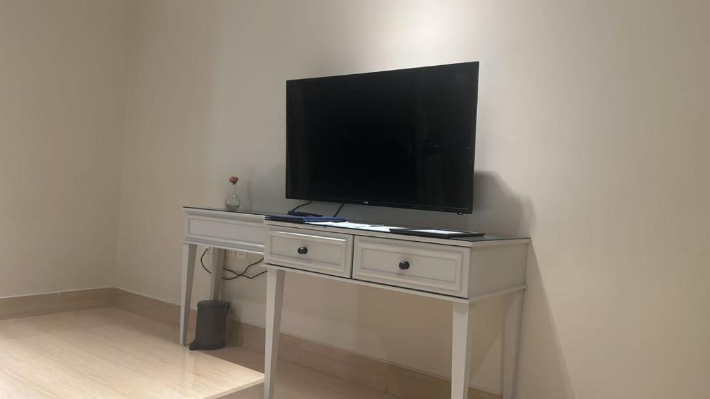 a tv on a white desk with a television on it at GAZLA in Riyadh