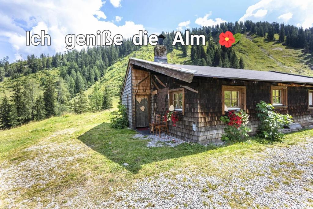 a small wooden cabin on a hill with the words left geniuses die alim at Almhütte Bairau Kaser in Lofer
