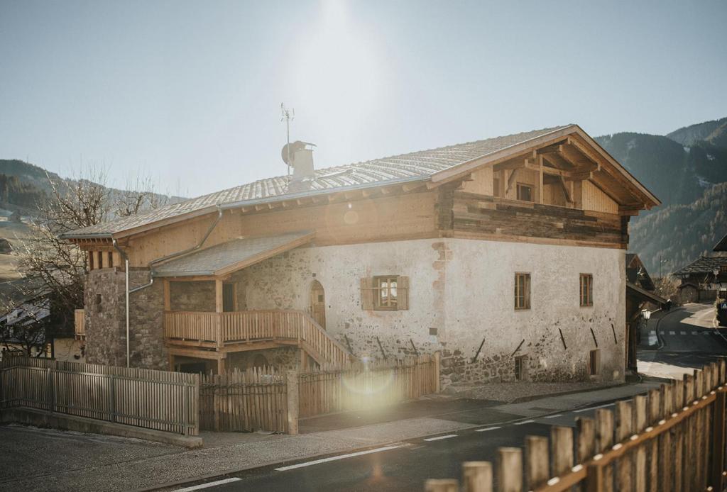a large wooden house with a fence in front of it at Alpin Chalet Samer in Sarntal