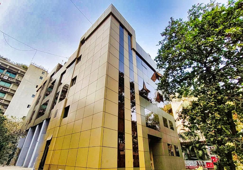 um edifício alto com janelas amarelas e azuis em Maxxvalue Hotel MIDC - Andheri em Mumbai