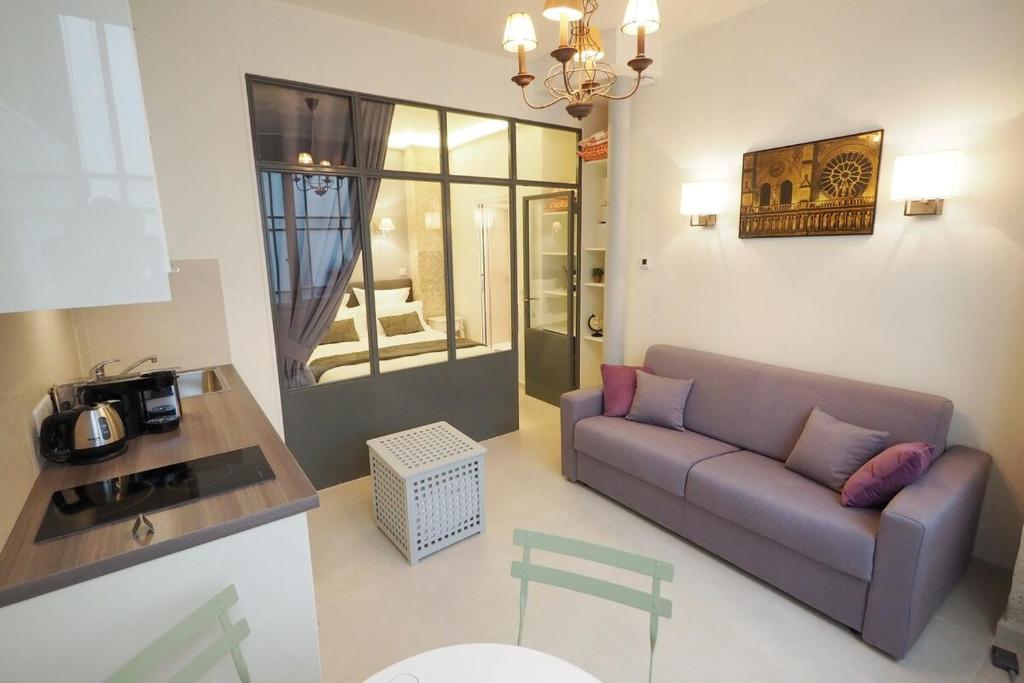 ein Wohnzimmer mit einem Sofa und einem Tisch in der Unterkunft Saint germain cosy in Paris