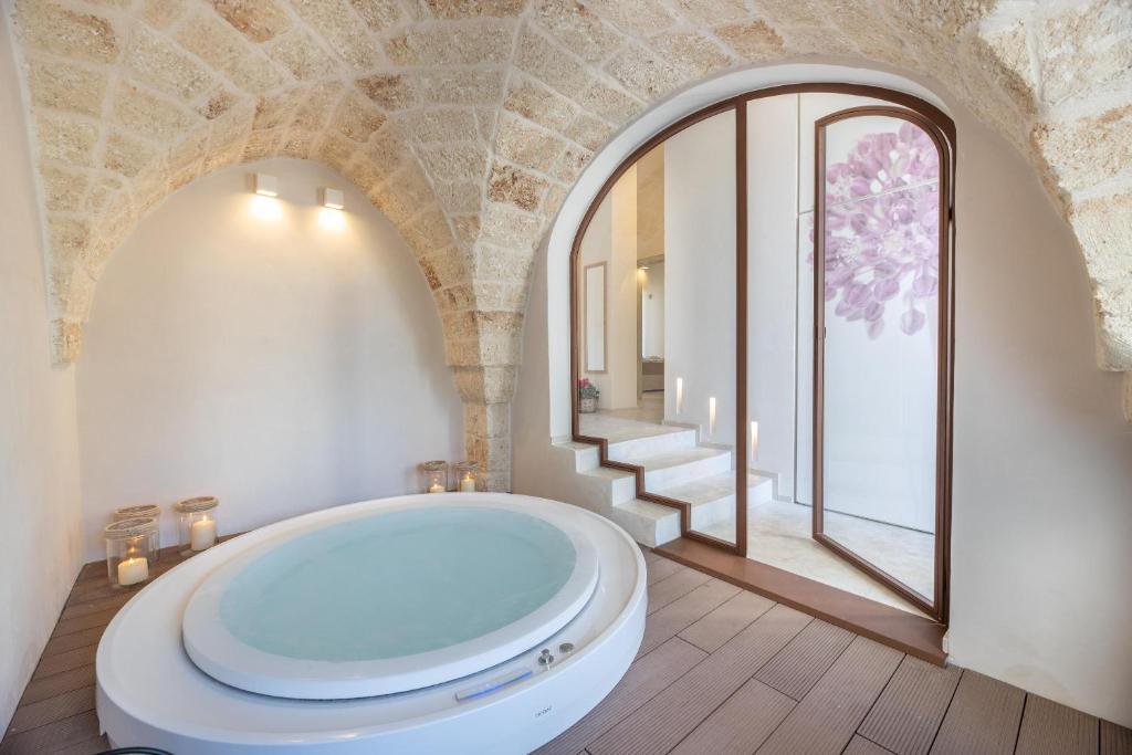 een badkamer met een groot bad en een raam bij Villa Perla del Mare in Carovigno