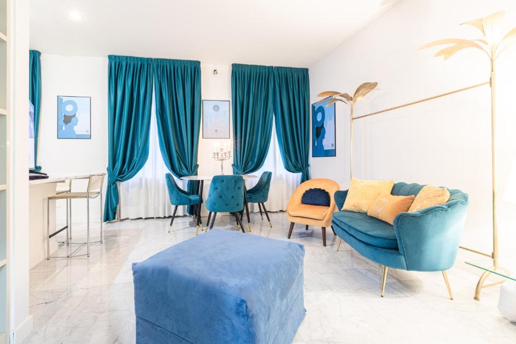 Monte Napoleone Split-level Terrace Apartment - Top Collection في ميلانو: غرفة معيشة مع كراسي زرقاء وطاولة
