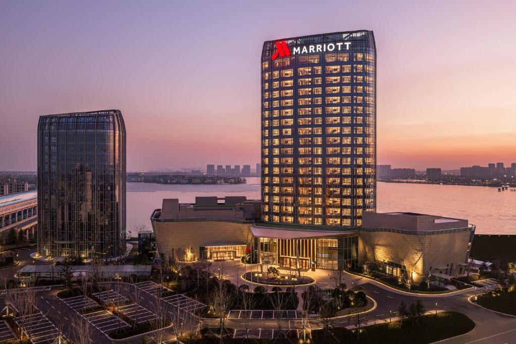 un grand bâtiment avec un panneau en haut dans l'établissement Qingdao Marriott Hotel Jiaozhou, à Qingdao
