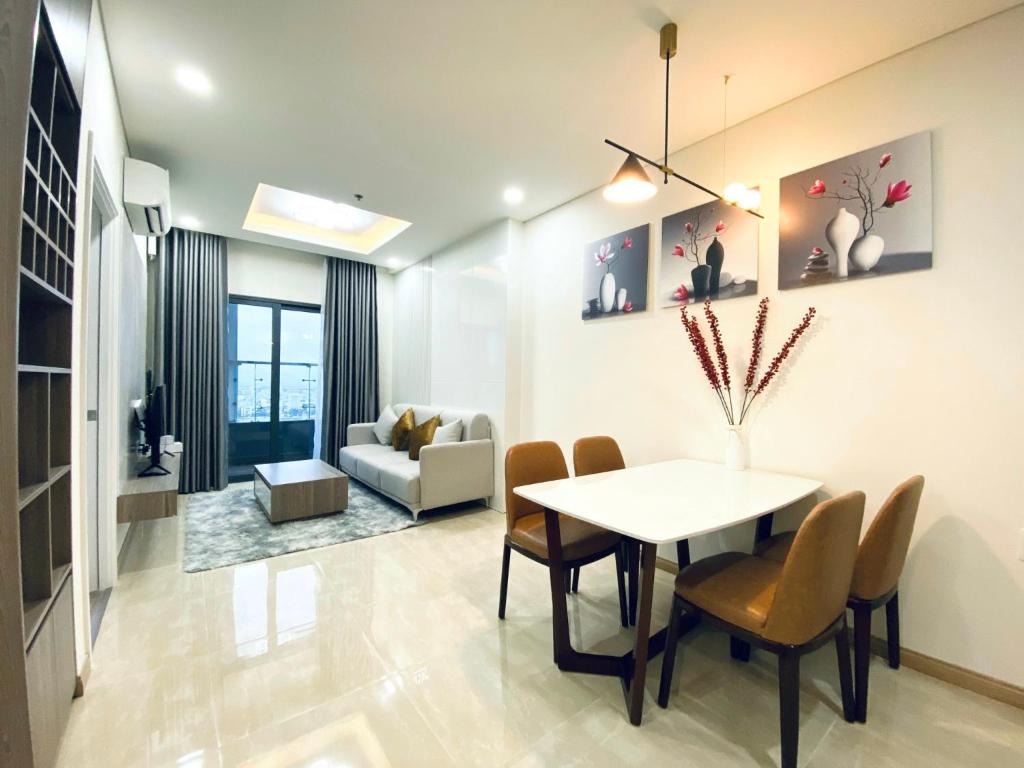 a dining room and living room with a table and chairs at Monarchy Apartment in Da Nang