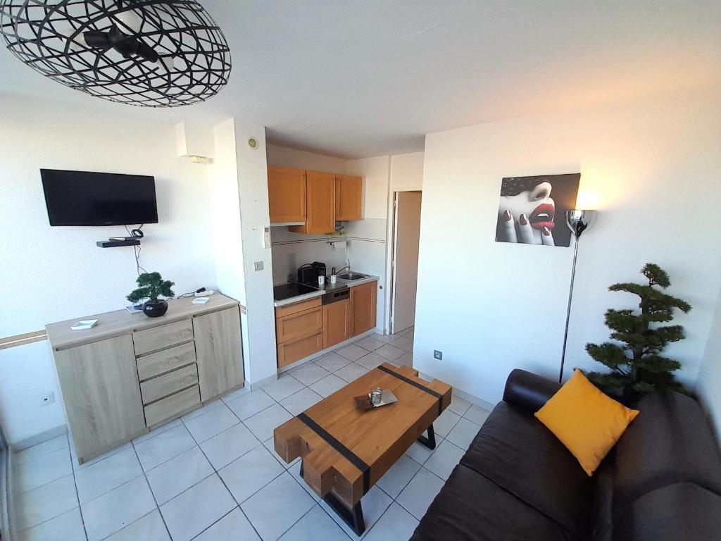 - un salon avec un canapé et une table dans l'établissement Appartement Village naturiste Leather, au Cap d'Agde
