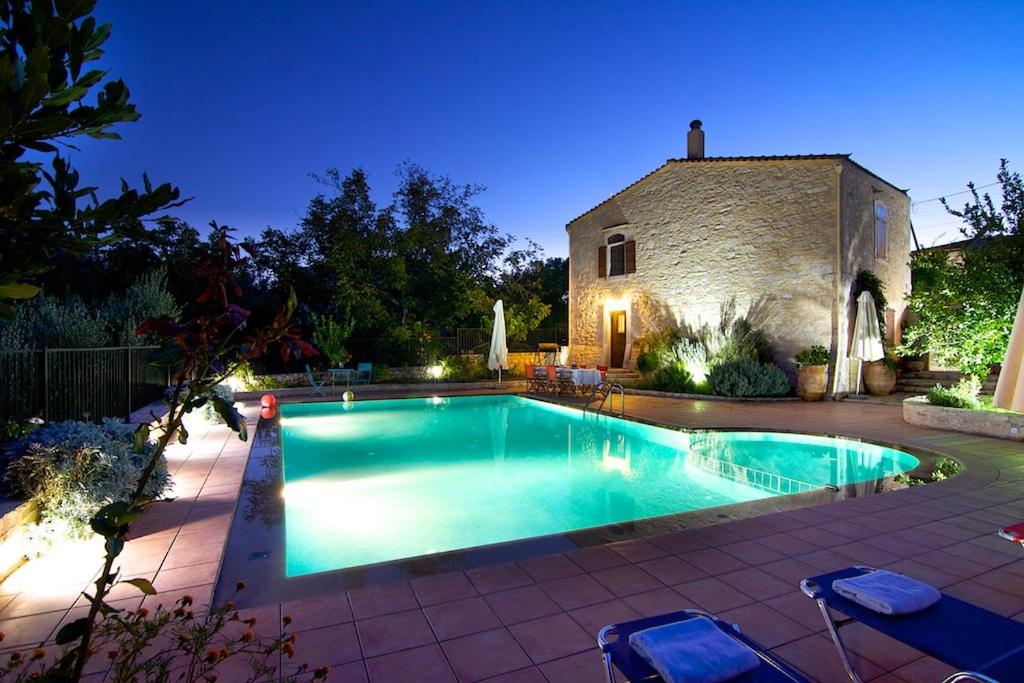 a swimming pool in front of a stone building at Allaria villa in Margarítai