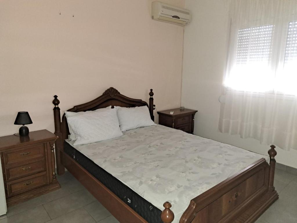 ein Schlafzimmer mit einem großen Bett und zwei Nachttischen in der Unterkunft warm home in Koropi
