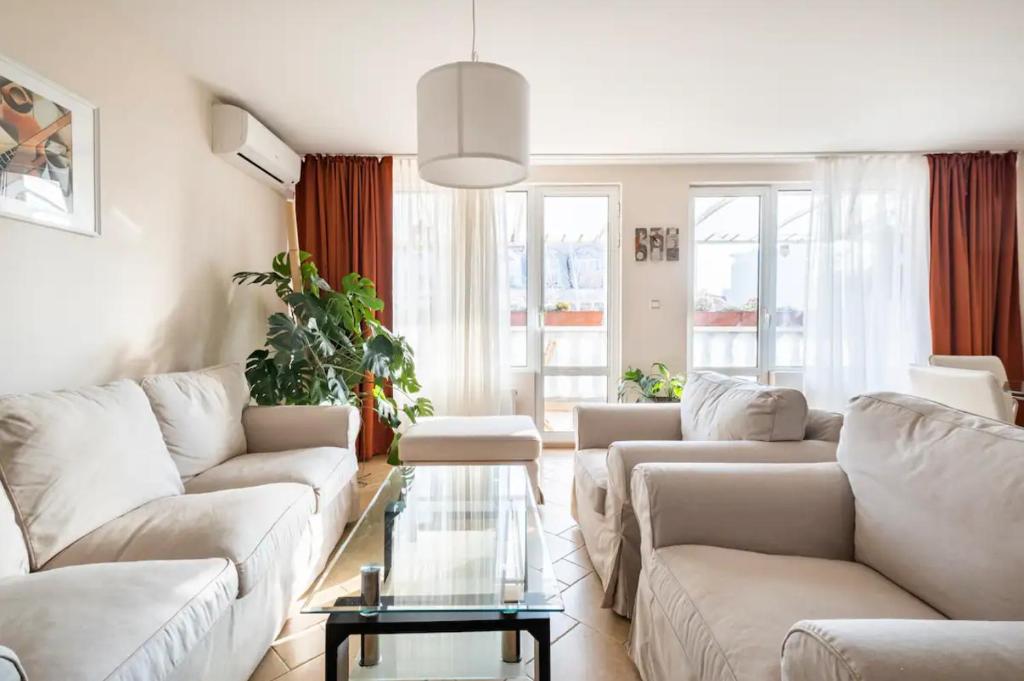 un soggiorno con divani bianchi e tavolo in vetro di 2BDR Duplex Apartment with Parking a Sofia