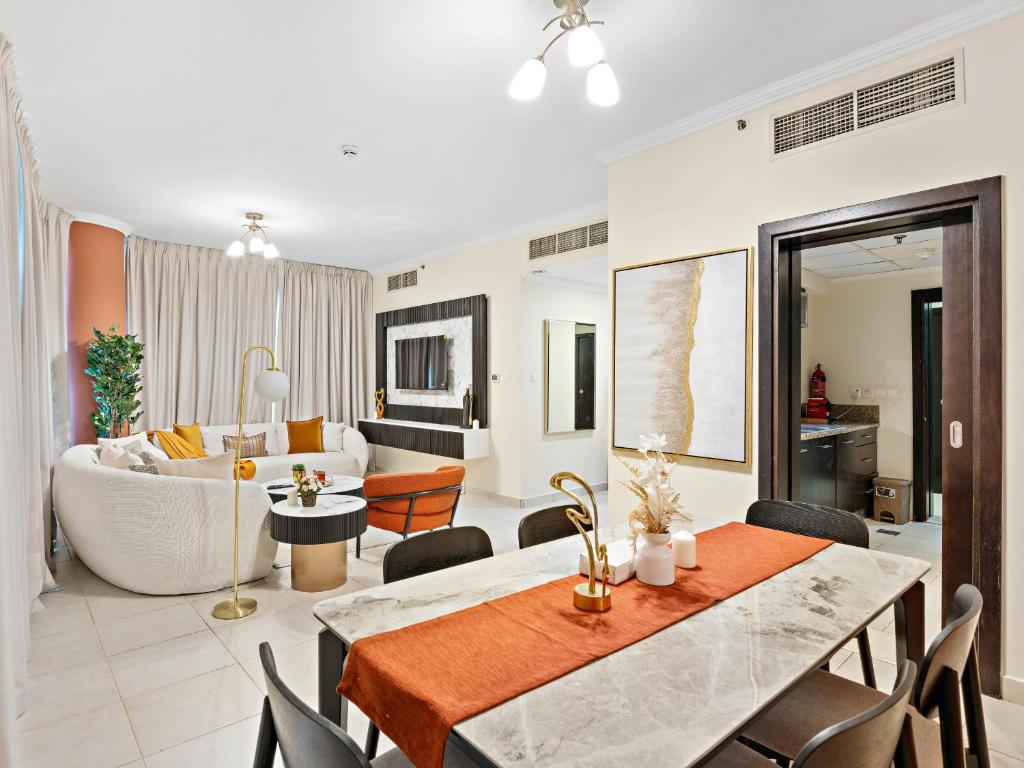 a living room with a couch and a dining room at Charming & Vibrant 1Bedroom In Marina Quay in Dubai