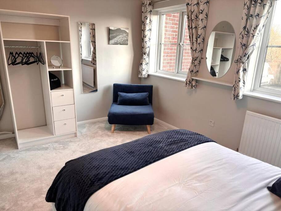 1 dormitorio con 1 cama y 1 silla azul en Apartment in Epsom With Free Parking, en Epsom