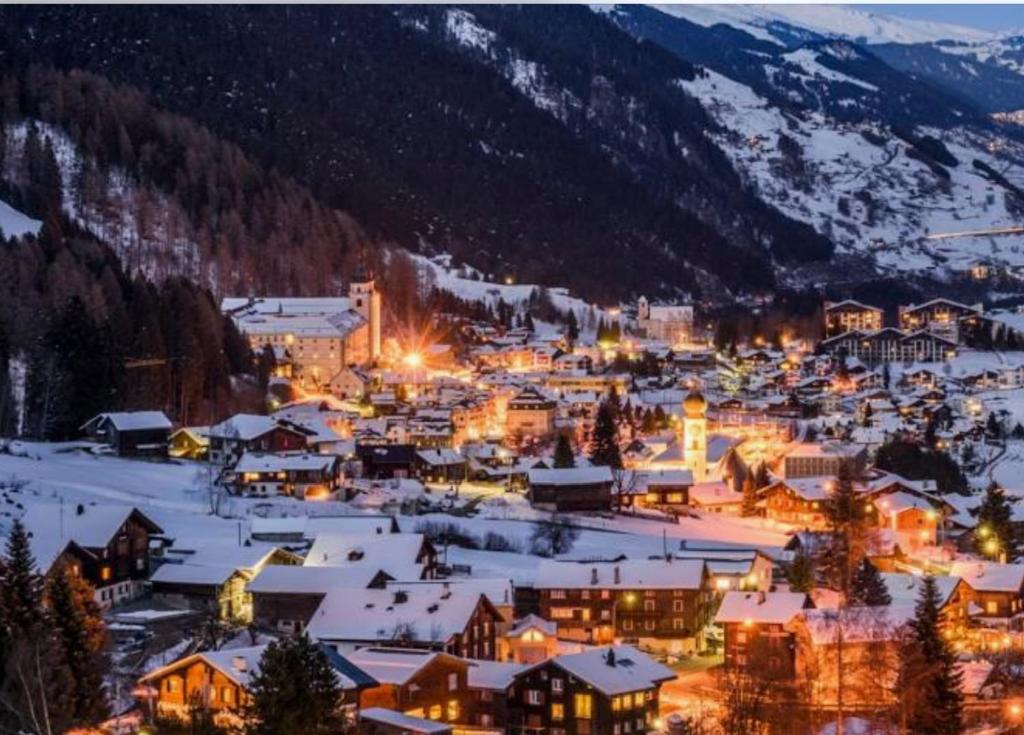 Une petite ville dans la neige la nuit dans l'établissement Disentiserhof, à Disentis