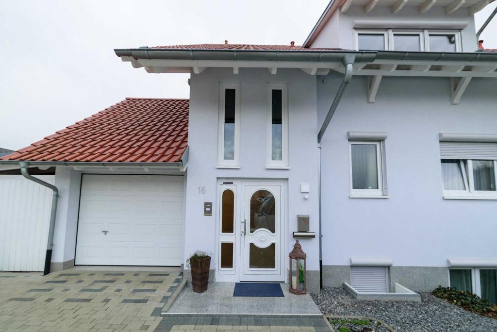 a white house with a red roof at Ferienwohnung-Herbolzheim in Herbolzheim