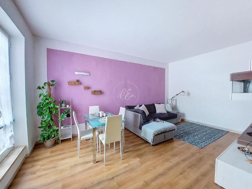 sala de estar con mesa y pared púrpura en Giuly House en Arenzano