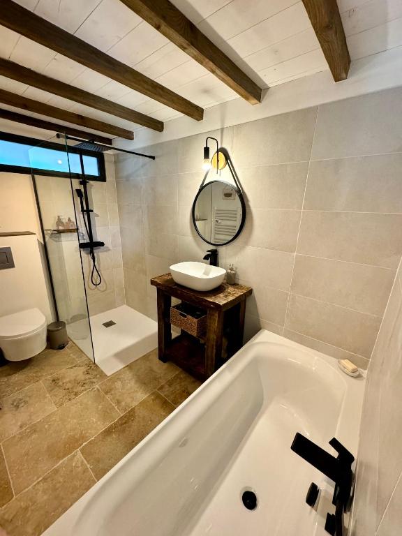 a bathroom with a tub and a sink and a mirror at Mas CamPau in Fontvieille