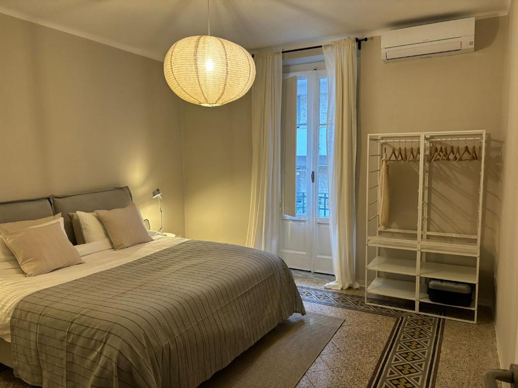 a bedroom with a bed and a window and a chandelier at Casa di Leonardo Elegant & Comfort in Bari