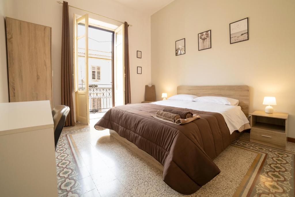 1 dormitorio con cama grande y ventana grande en Centro Stazione Aeroporto Wi-Fi&Self Check-In en Palermo